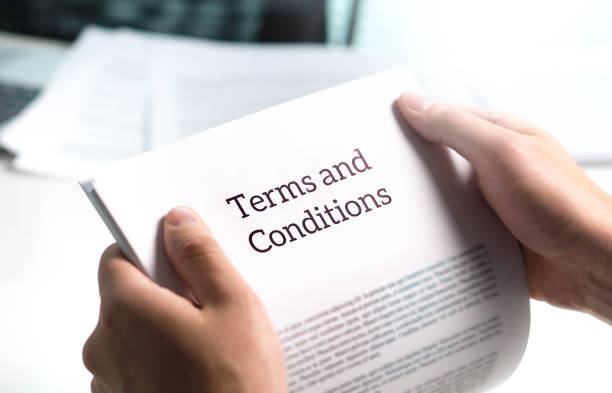 A person holding onto a paper that says terms and conditions